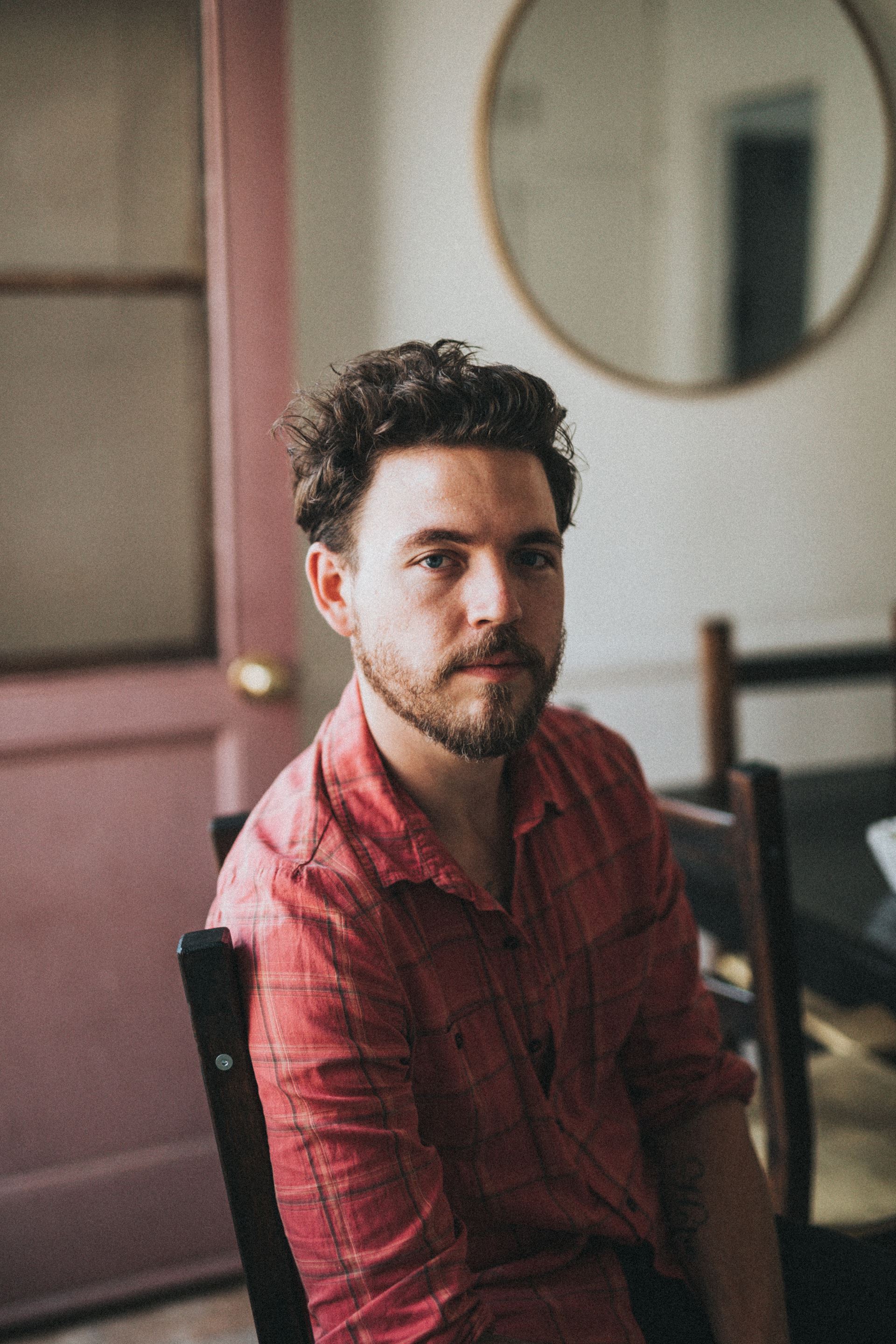a man sitting in front of a mirror posing for the camera